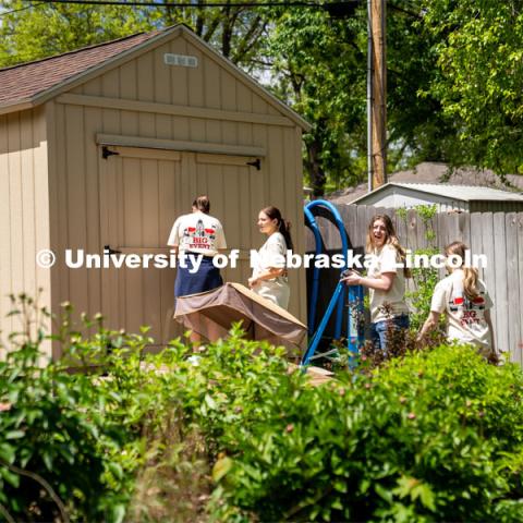 Members of Tri Delta, Sophie Helm, Alyssa Dunlap, Rachel Nelson, and Kate Freeman, go to a homeowner’s shed to put away tools that were provided to them during the Big Event. May 4, 2024. Photo by Kirk Rangel for University Communication.